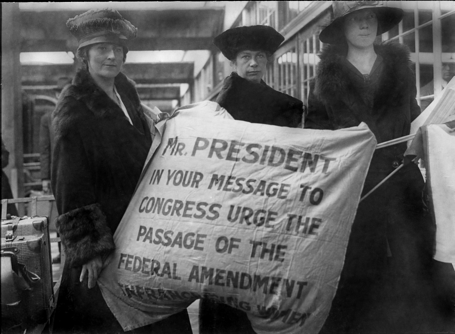 Amelia Himes Walker with two other suffragists holding a sign addressing the president